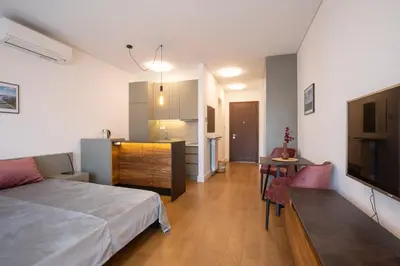a bedroom with a bed and a table and a kitchen at Belgrade Center Apartment Lux Residence in Belgrade