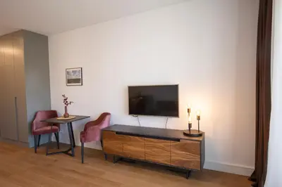 a living room with a tv and a table and chairs at Belgrade Center Apartment Lux Residence in Belgrade