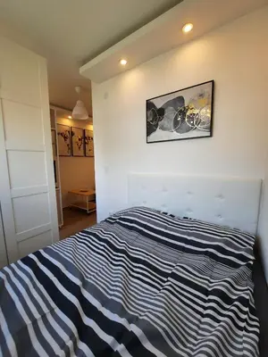 a bedroom with a blue and white striped bed at Apartment Piccolo Ada in Belgrade