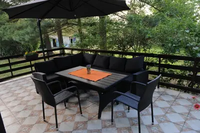 a table and chairs with an umbrella on a patio at Vikend-kuca Vevericji Kraj in Vranić