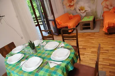 a dining room table with a green and white table cloth at Vikend-kuca Vevericji Kraj in Vranić