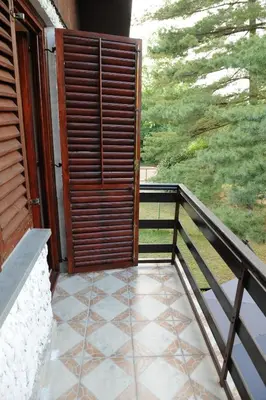 a porch with a wooden door and a balcony at Vikend-kuca Vevericji Kraj in Vranić