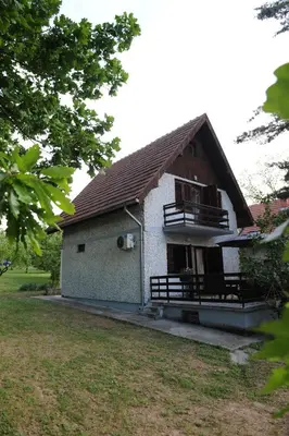 a small house with a balcony and a yard at Vikend-kuca Vevericji Kraj in Vranić