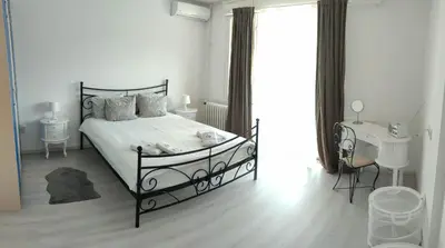 a white bedroom with a black bed and a sink at Apartment 51 - Bright, spacious, lux 1 bedroom in the city center - Stari grad in Belgrade