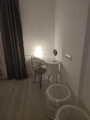 a room with a table and a chair and a lamp at Apartment 51 - Bright, spacious, lux 1 bedroom in the city center - Stari grad in Belgrade