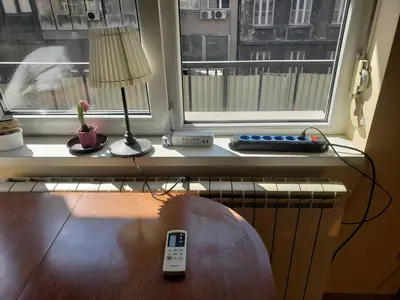 a window with a remote control sitting on a table at Private cozy room 2 with shared kitchen in appartment in Belgrade