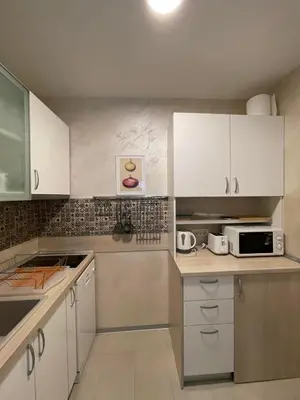 a kitchen with white cabinets and a microwave at Apartment Belgrade Nº3 in Belgrade