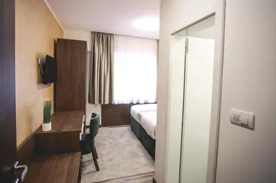 a hotel room with a bed and a desk at VILA MB in Ruma