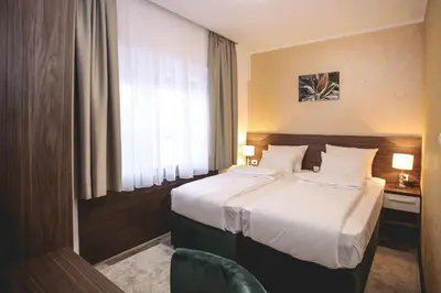 a hotel room with two beds and a window at VILA MB in Ruma