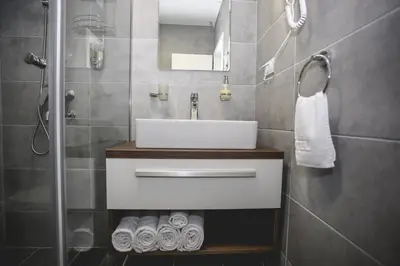 a bathroom with a white sink and a shower at VILA MB in Ruma