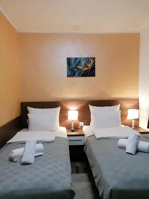 a hotel room with two beds and two lamps at VILA MB in Ruma