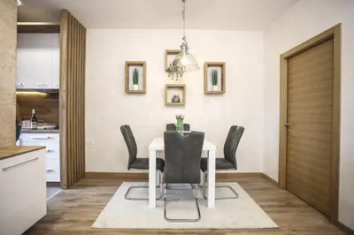 a dining room with a white table and black chairs at VILA MB in Ruma