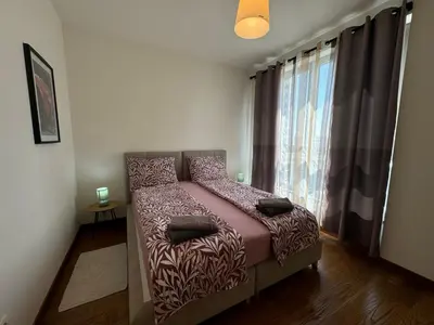 a bedroom with a bed in a room with a window at BW Arcadia deluxe apartments in Sajmište