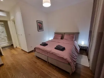 a bedroom with a large bed with pink pillows at BW Arcadia deluxe apartments in Sajmište