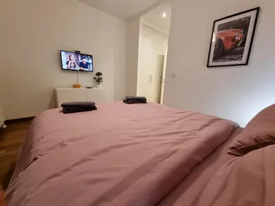 a large bed in a room with a tv on the wall at BW Arcadia deluxe apartments in Sajmište