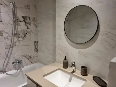 a bathroom with a sink and a mirror and a tub at BW Arcadia deluxe apartments in Sajmište