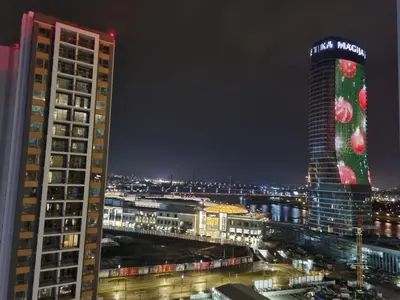 a view of a city at night with two tall buildings at BW Arcadia deluxe apartments in Sajmište