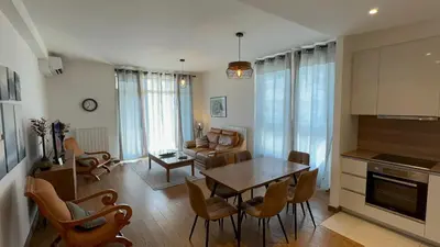 a kitchen and living room with a table and chairs at BW Arcadia deluxe apartments in Sajmište