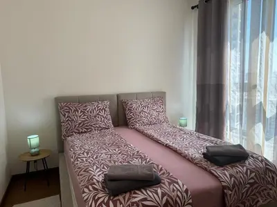 a bed with pillows on it in a room with a window at BW Arcadia deluxe apartments in Sajmište