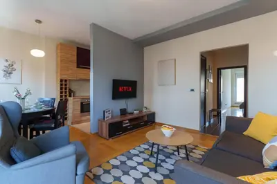 a living room with two blue couches and a table at Quince Apartment-City Center-Free parking in Belgrade