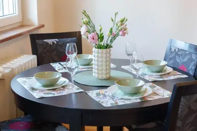a dining room table with a vase of flowers on it at Quince Apartment-City Center-Free parking in Belgrade
