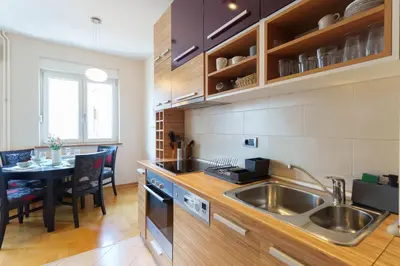 a kitchen with a sink and a dining table at Quince Apartment-City Center-Free parking in Belgrade