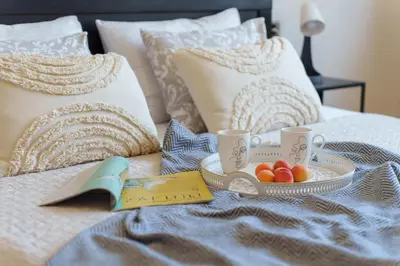 a breakfast tray with fruit on a bed at Quince Apartment-City Center-Free parking in Belgrade