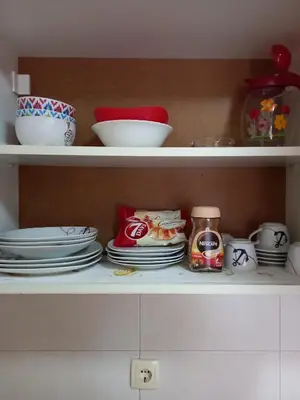 a shelf with plates and bowls and other dishes at Luna Apartment in Surčin