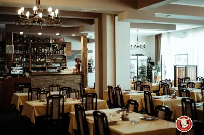 a restaurant with tables and chairs and a bar at Luna Apartment in Surčin