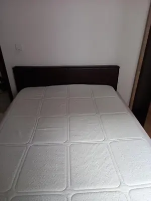 a bed in a room with a white mattress at Luna Apartment in Surčin