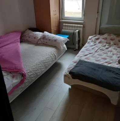 a bedroom with two beds and a window at Sara Apartment in Surčin