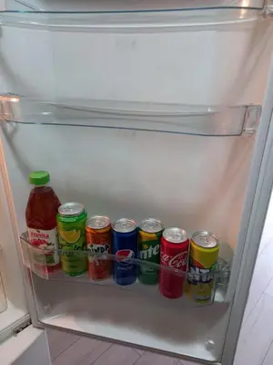 a refrigerator filled with lots of cans of soda at Sara Apartment in Surčin