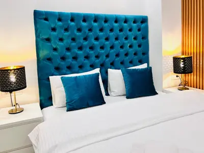 a bedroom with a large bed with a blue headboard at Vivio 2 Luxury Apartment in Belgrade