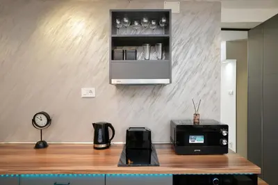 a kitchen with a counter with a microwave and a clock at River&Bike Apartment in Belgrade