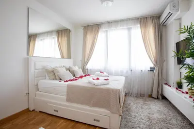 a bedroom with a white bed with flowers on it at Belgrade Waterfront Apartments - River View in Belgrade