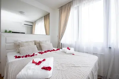 a bedroom with two beds with red roses on them at Belgrade Waterfront Apartments - River View in Belgrade