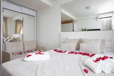 a bedroom with a white bed with red roses on it at Belgrade Waterfront Apartments - River View in Belgrade