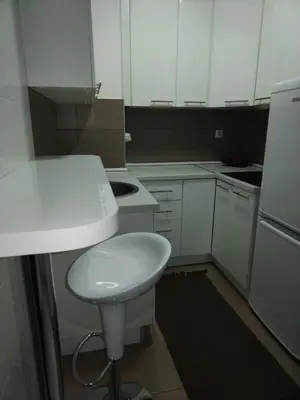 a small kitchen with white cabinets and a white sink at Downtown lux in Smederevo