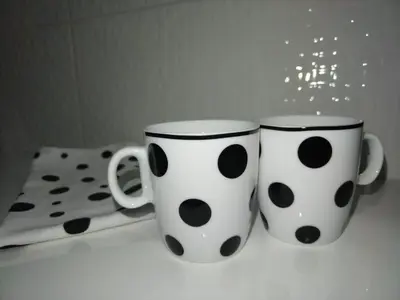 two polka dot coffee mugs sitting on a table at Downtown lux in Smederevo