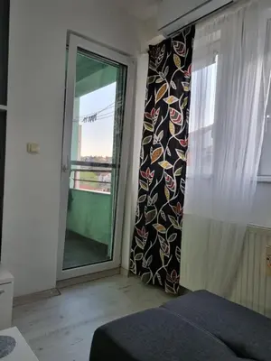 a bedroom with a window and a bed and a curtain at Downtown lux in Smederevo