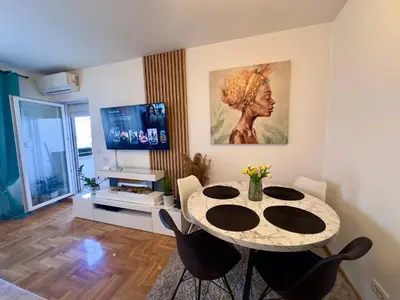 a living room with a table and a television at Belgrade Apartment 3 in Zvezdara