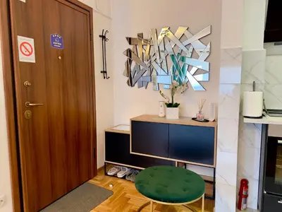 a room with a wooden door and a green stool at Belgrade Apartment 3 in Zvezdara