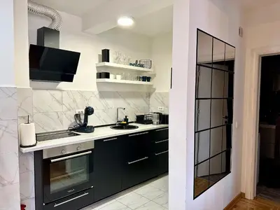 a kitchen with black and white appliances and a window at Belgrade Apartment 3 in Zvezdara
