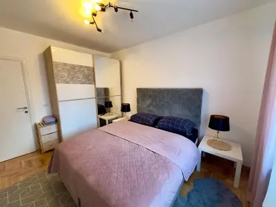 a bedroom with a bed and two tables and a lamp at Belgrade Apartment 3 in Zvezdara