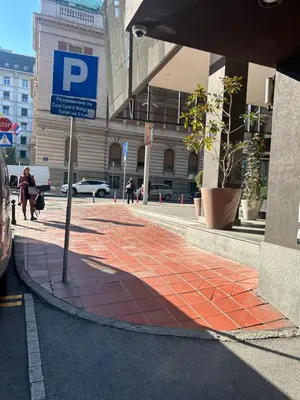 a parking sign on a sidewalk in front of a building at Paradise Museum City Center in Belgrade