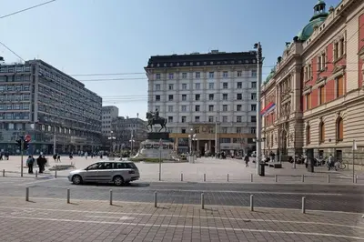 a car driving down a city street with buildings at Paradise Museum City Center in Belgrade