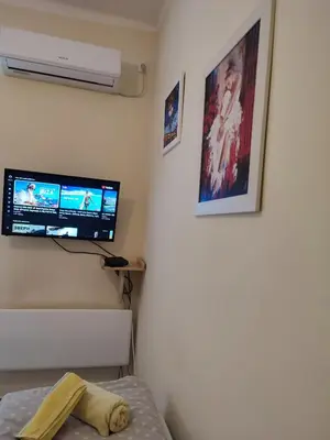 a bedroom with a bed and a tv on the wall at Orion Apatman in Belgrade