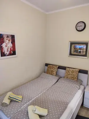 a bedroom with a bed with two slippers on it at Orion Apatman in Belgrade