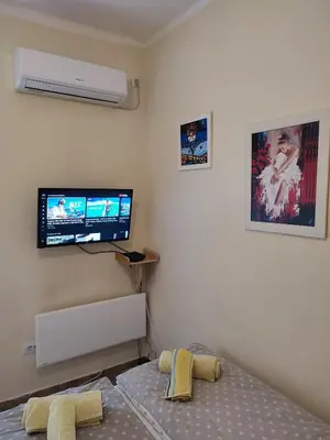 a bedroom with a bed and a flat screen tv at Orion Apatman in Belgrade