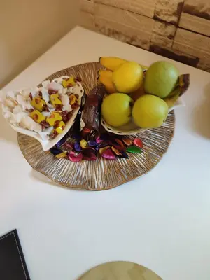 a plate with a bowl of fruit on a table at Orion Apatman in Belgrade